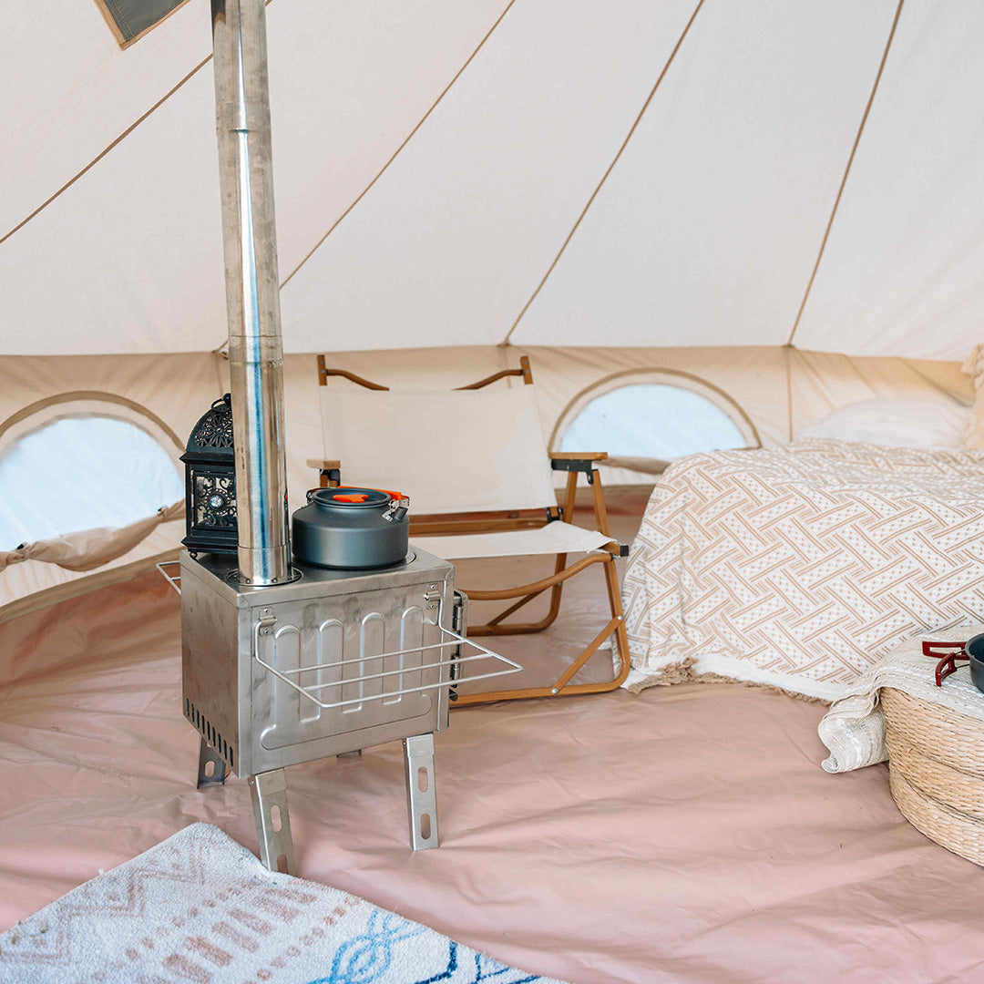 Interior of a tent with a metal stove and cooking pot.