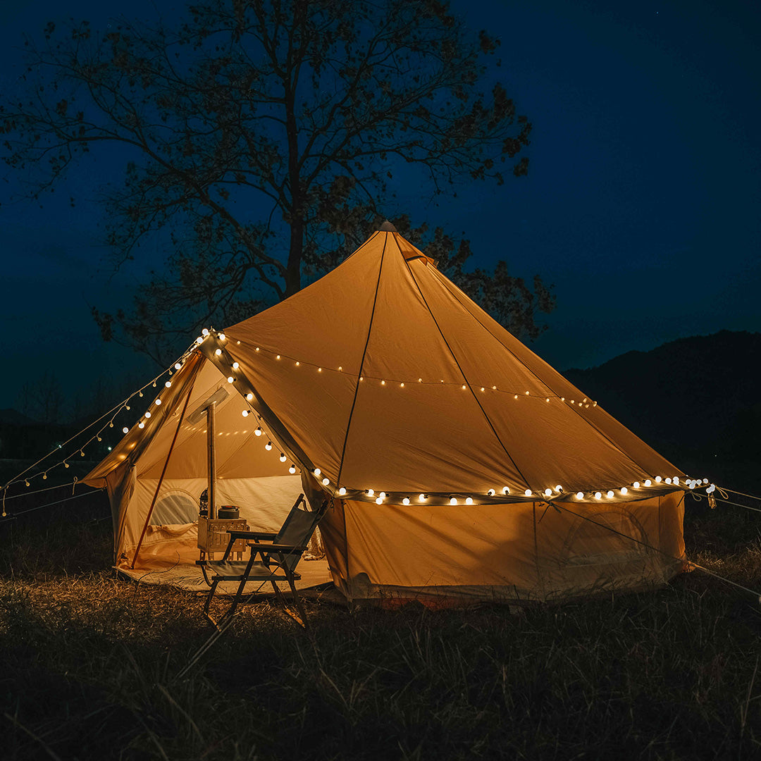 Beige tent with string lights in a dark outdoor setting