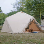 Beige camping tent set up in a grassy area with trees in the background
