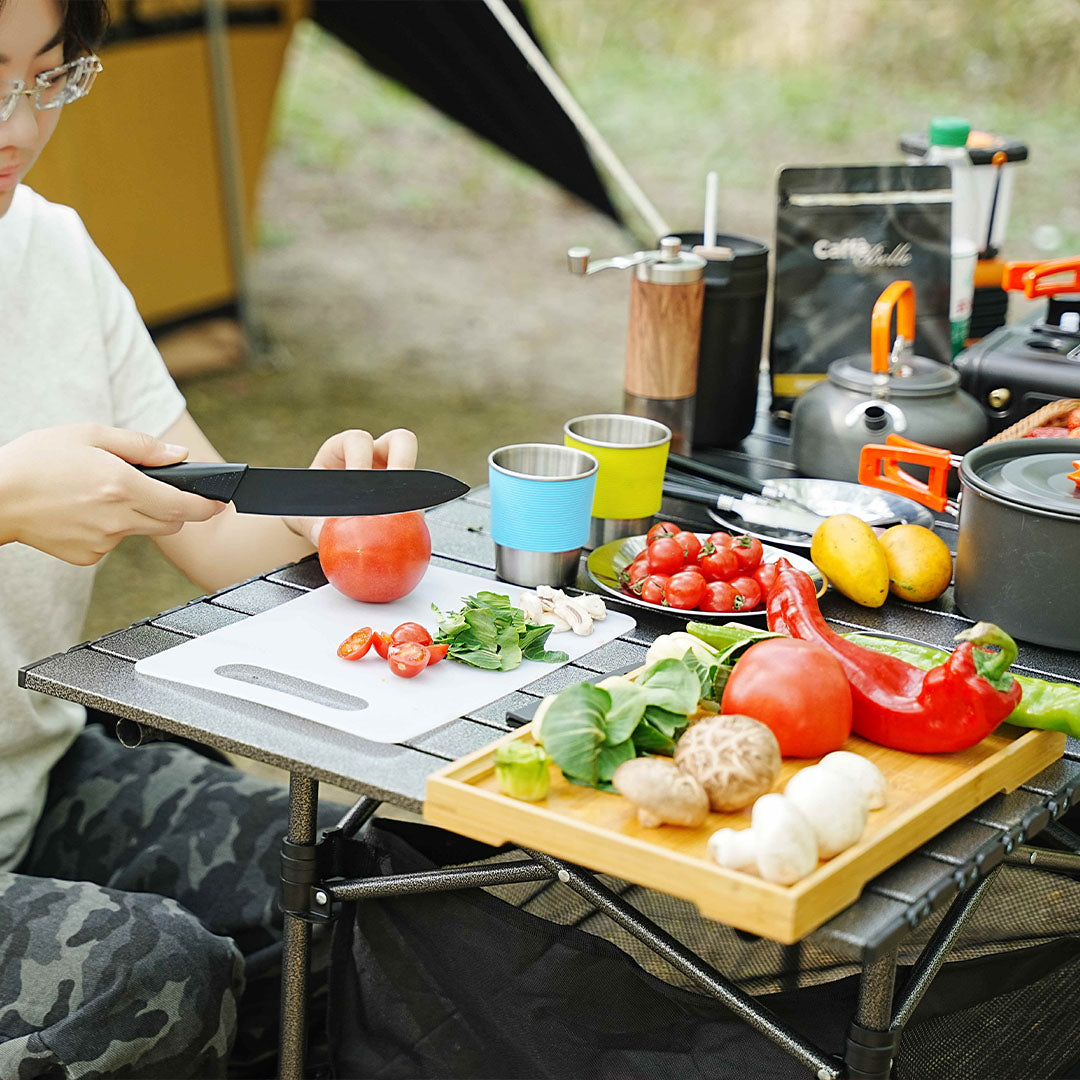 Premium camping cutlery and accessories beautifully arranged in an outdoor setting, showcasing quality craftsmanship and functional design for glamping