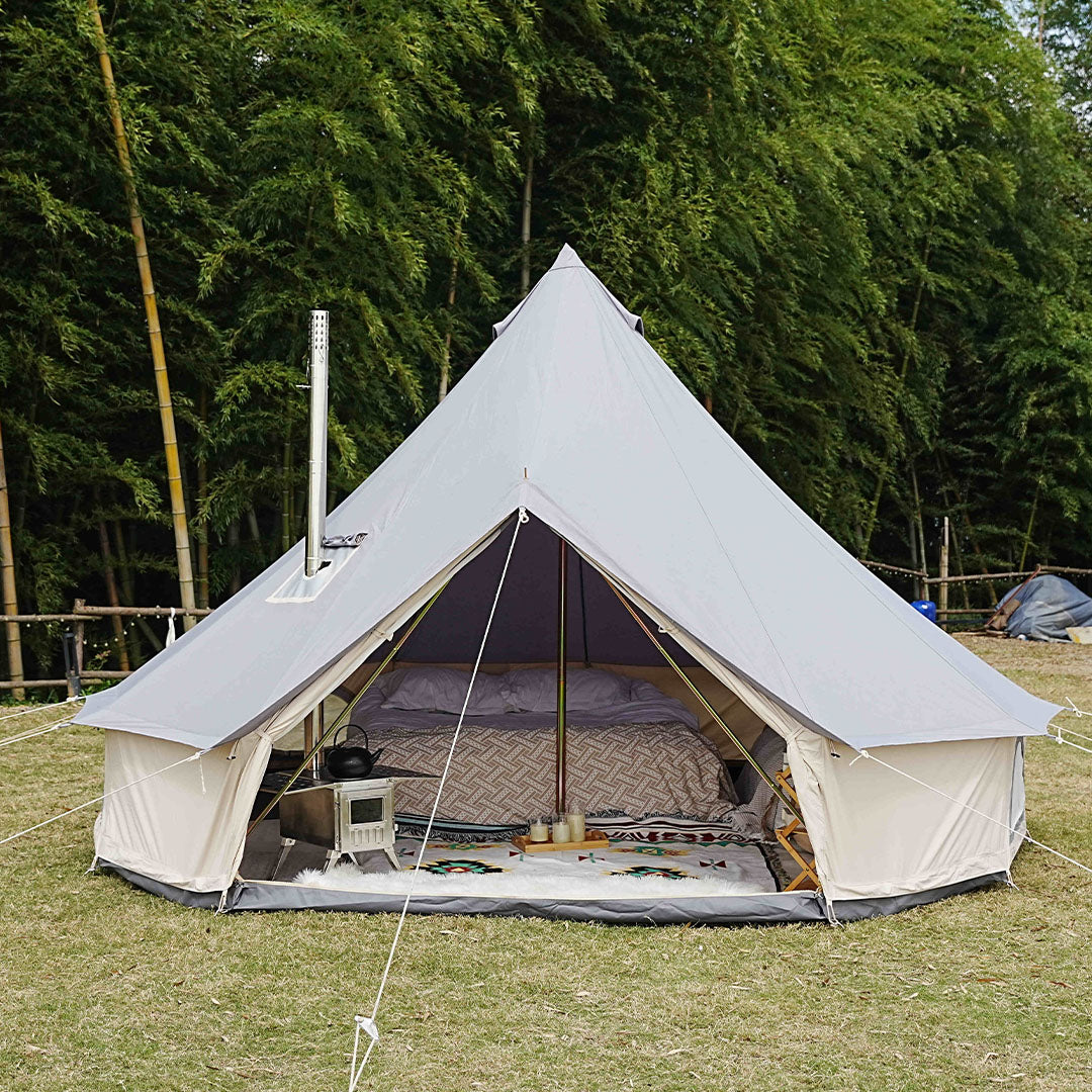 Bell tent in a forest setting with visible interior setup