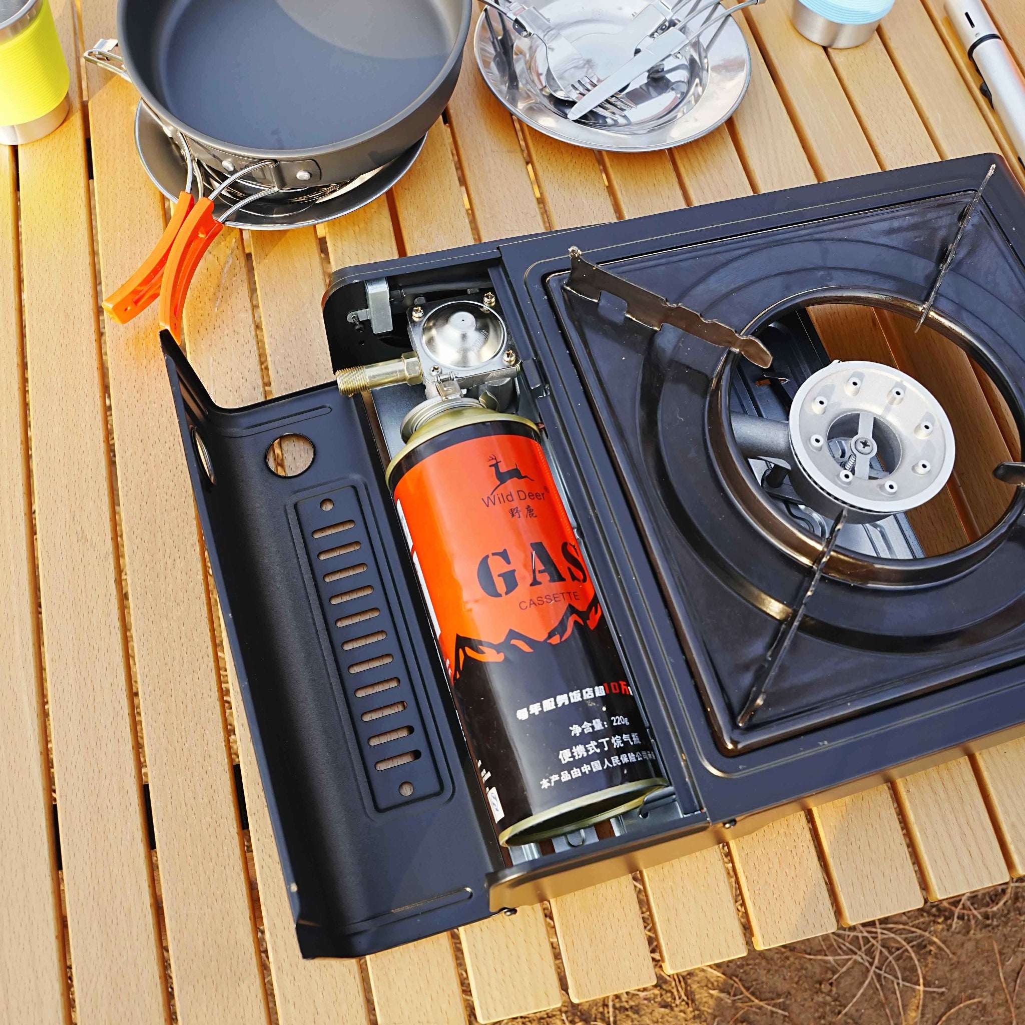 Portable gas stove with a canister on a wooden surface